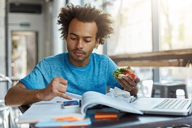 A person eating and studying